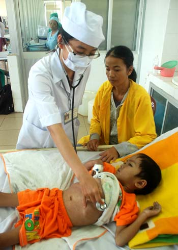 Bác sĩ đang chăm sóc cho cậu bé 5 tuổi ở bệnh viện. Ảnh: Trí Tín